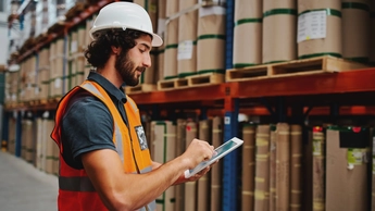 Handsome worker using touch screen tablet to check stock entering information