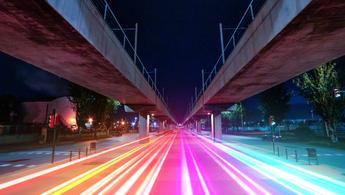 Visualizing 5G with colorful light trails connecting urban spots in finite vanishing point.