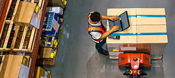 overhead view of man working on laptop in warehouse