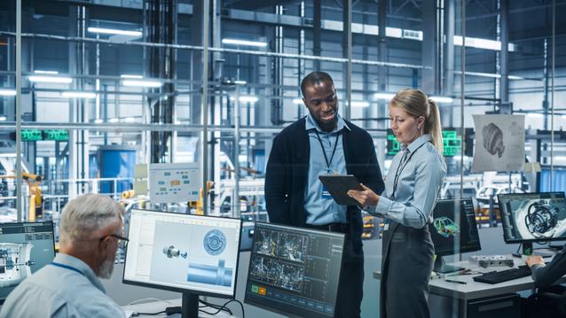 Car Factory Office: Female Engineer Talks with Male Scientist, Use Tablet Computer to Design Production Conveyor for Advanced Power Engines. Automated Robot Arm Assembly Line Manufacturing Vehicles