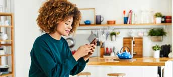 Woman using smartphone at home during coronavirus outbreak - stock photo