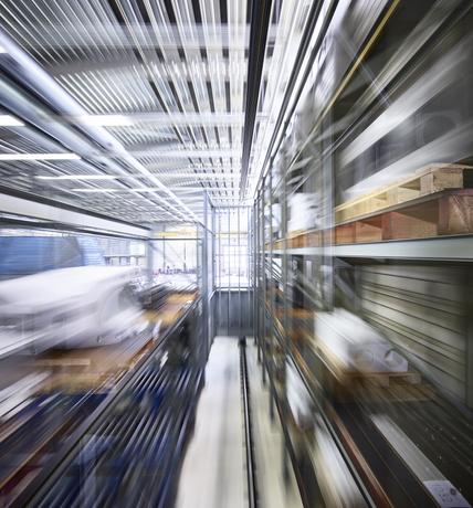 Narrow alley amidst blurred motion of racks