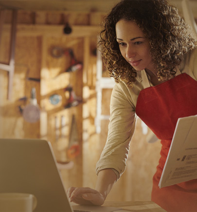 woman wearing apron working on computer