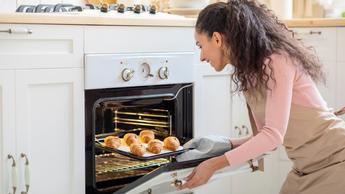 woman taking food out of an oven