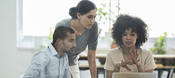 Colleagues Talking While Using Laptop