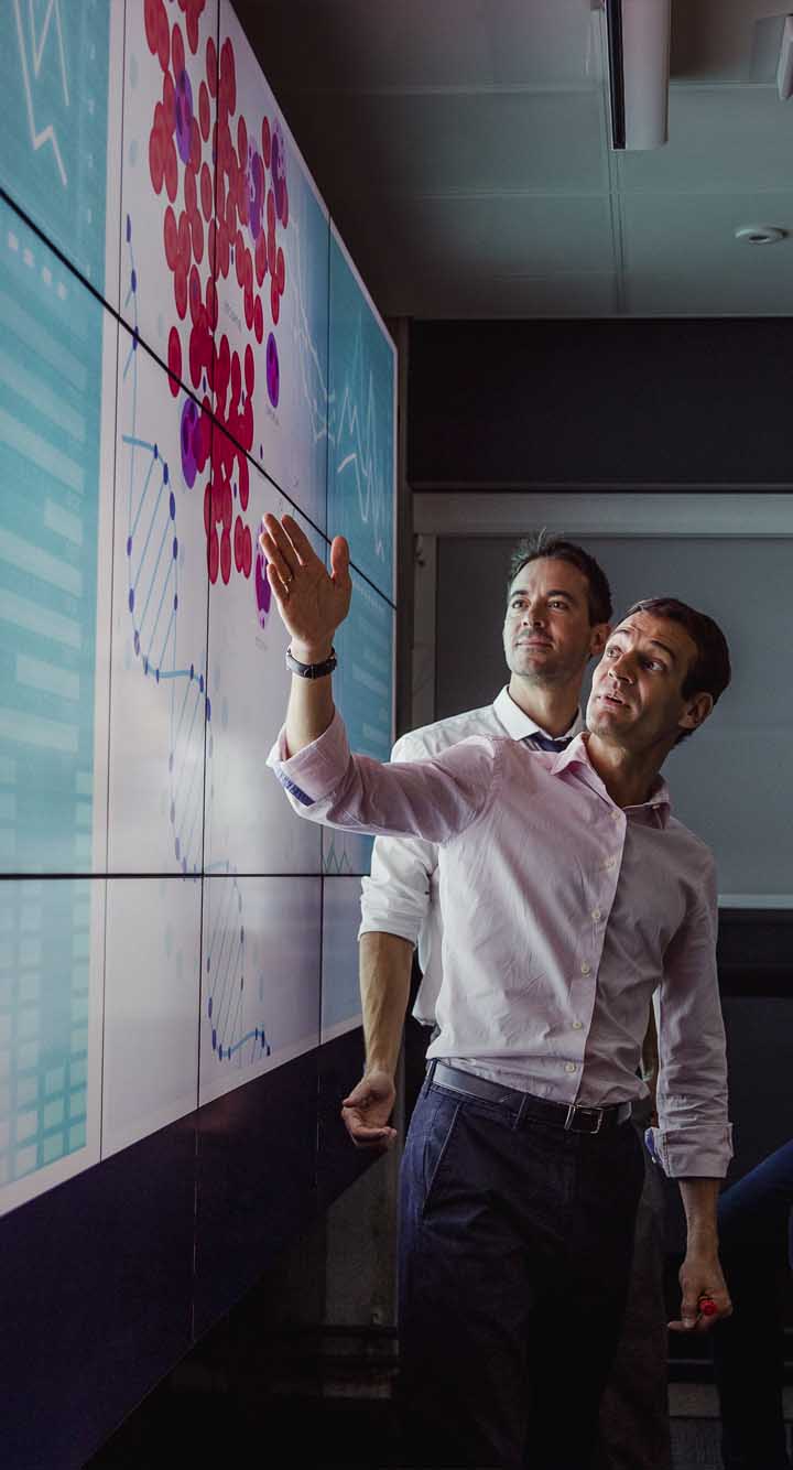 adults viewing data on a large display screen