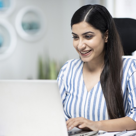 woman happily working at laptop
