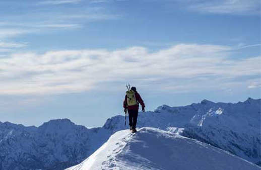 Climber reaching a snowy mountain top