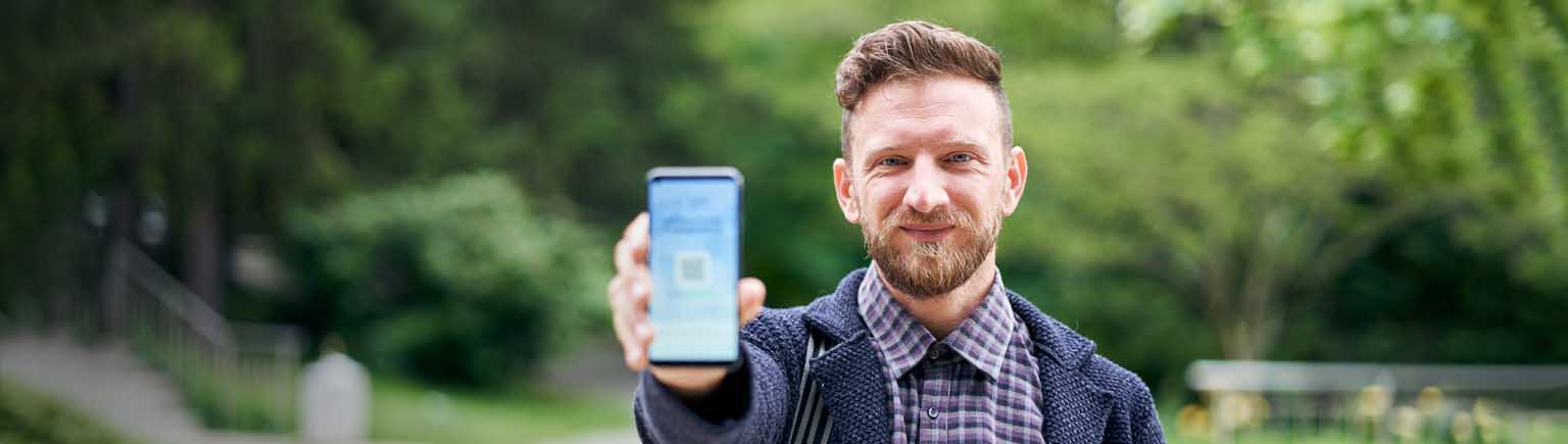 happy man holding phone out to show app
