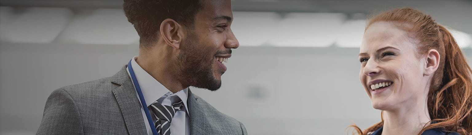 a male and female executive smiling