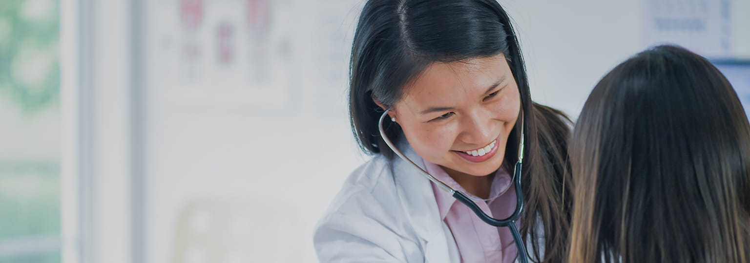 Female doctor wearing stethoscope checking patient