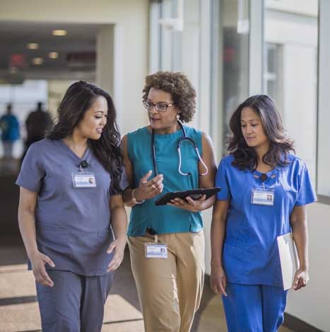 two doctors walking with hospital staff