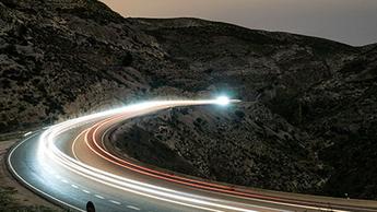 cars driving at night on mountain roads