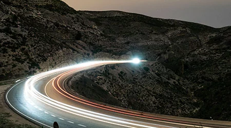 cars driving at night on mountain roads