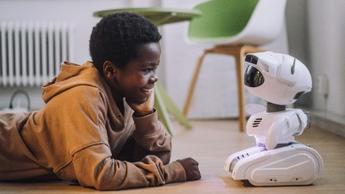 young boy smiling at robot toy