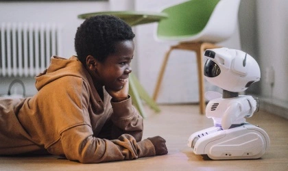 young boy smiling at robot toy