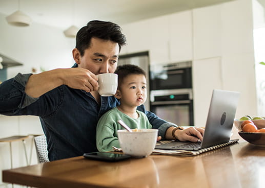 man trying to work with a child on his lap