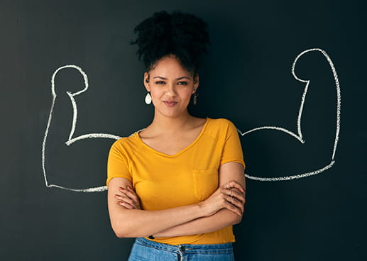 Woman standing in front of a chalkboard drawing of a strong person