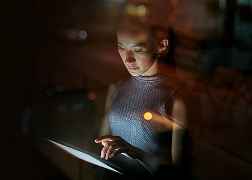 person in the dark using tablet PC