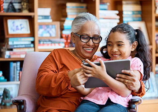 grandmother and granddaughter sitting together laughing