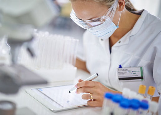 healthcare professional wearing a mask and working on a tablet