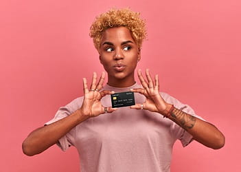 woman holding credit card with pink background
