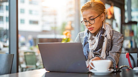 woman working on laptop in coffee shop