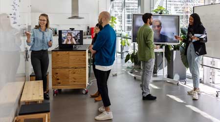 Team of co-workers collaborating as they are joined by remote team mates