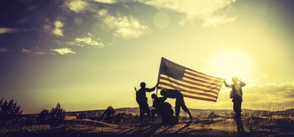 WWII Soldiers Raising The American Flag At Sunset