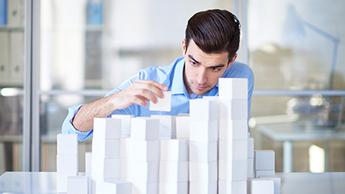Businessman building towers with blocks