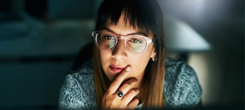 woman with glasses looking at screen
