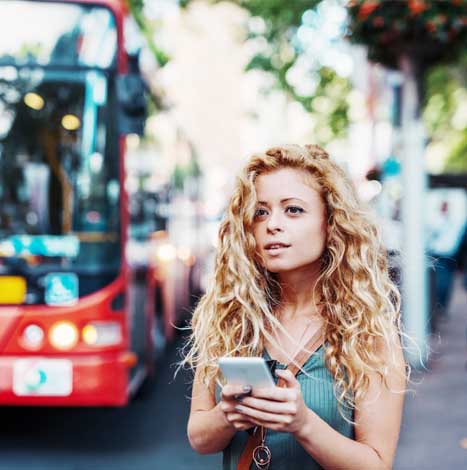 Woman using mobile app on bus stop