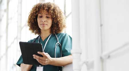 A healthcare worker checks a tablet PC