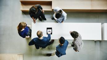 Top view of a group of people standing around a table