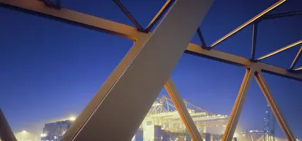 Yellow steel bridge and container terminal at dawn