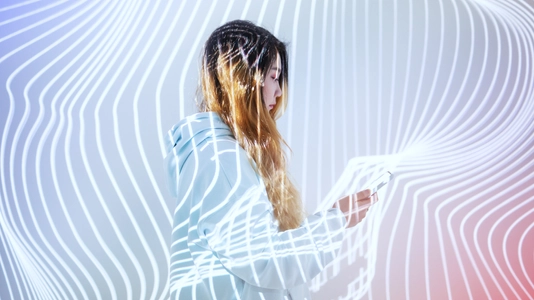 Woman using mobile phone in the holographic background 