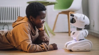 young boy smiling at robot toy