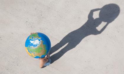boy holding a globe with his shadow on the ground
