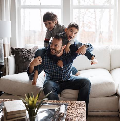 happy family showing two boys climbing on dad