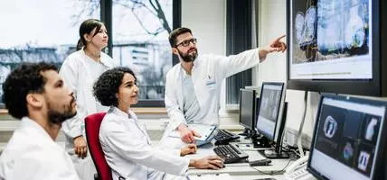 A team of doctors looking at lab results together on monitors