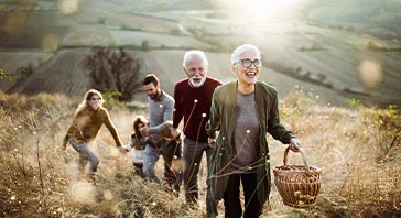 Happy senior woman leading her family to perfect picnic place on the hill