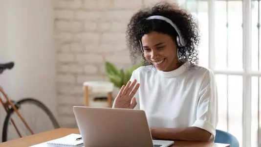 Happy african american young business woman wearing headphones