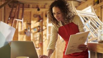 woman wearing apron working on computer