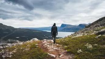 man hiking on a mountain path solo