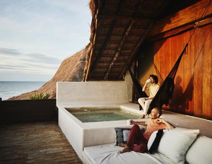couple relaxing on deck of luxury hotel