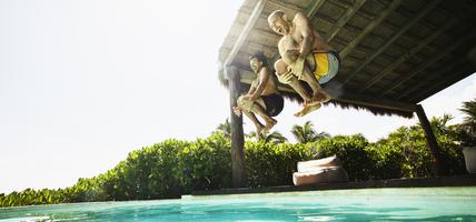 two men jumping into pool