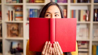 woman with book covering half her face