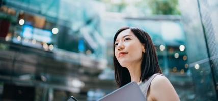 A woman standing with laptop in office