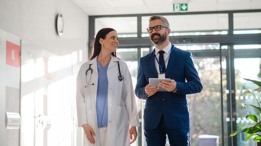 Two medical professionals walking together and engaging in conversation