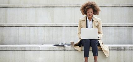 young businesswoman using laptop on steps